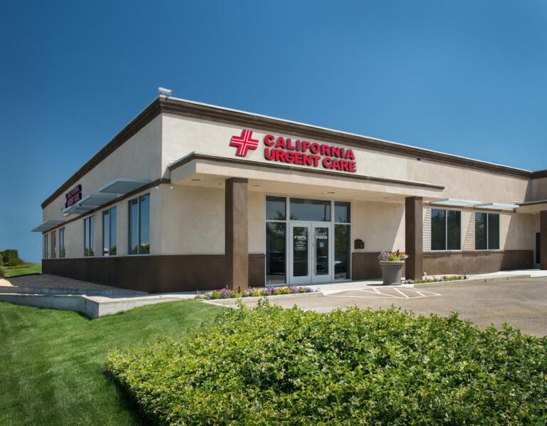 A one-story beige building with large windows and a sign reading “California Urgent Care” above the entrance. There are flower beds, green grass, and clear blue sky in the background. | California Urgent Care Center