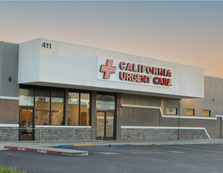 A modern building with a sign reading California Urgent Care above the entrance, large windows, and an empty parking lot in front. | California Urgent Care Center
